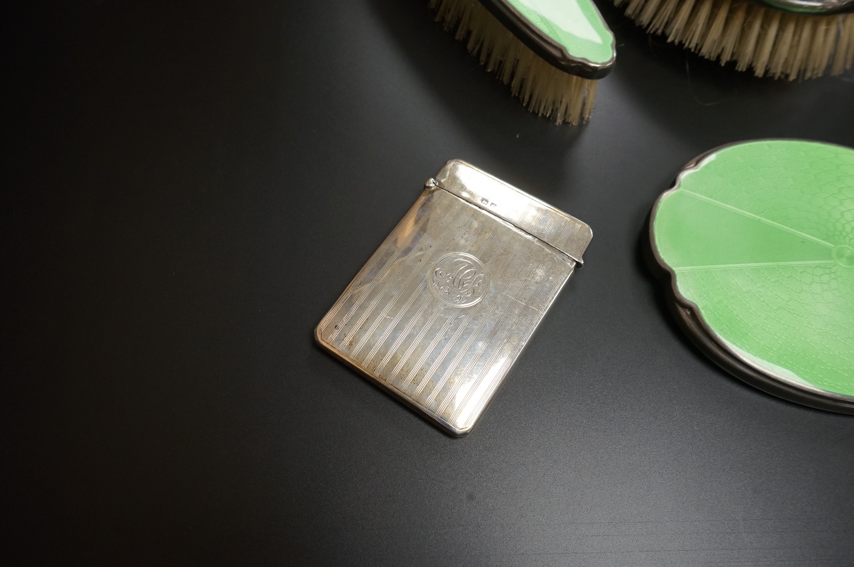 A George V silver rectangular card case by William Henry Sparrow, Birmingham, 1913, 89mm, a modern silver mounted circular photograph frame and five other items including a three piece silver plate and enamel mirror and